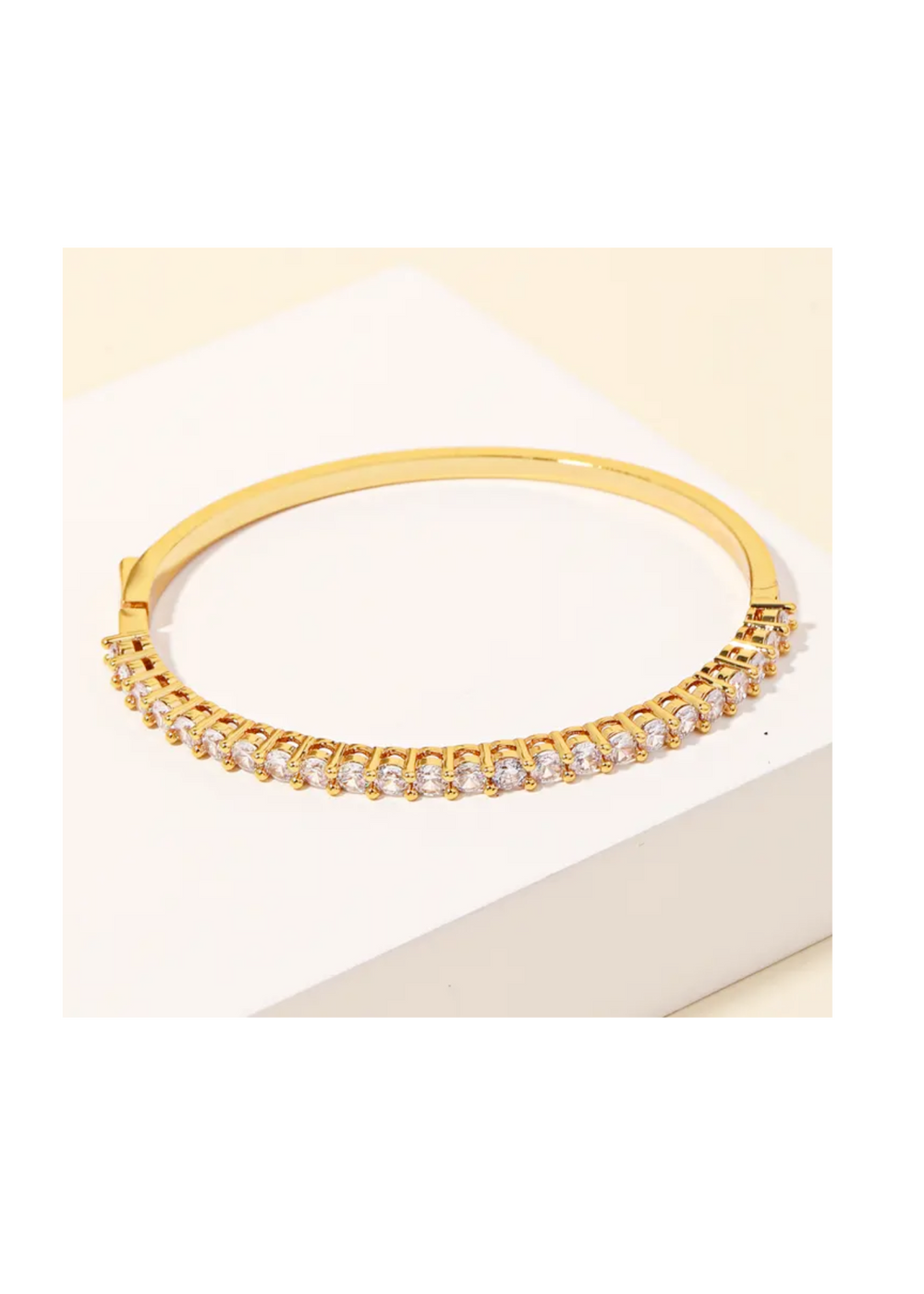 This stunning bangle features a gorgeous gold and rhinestone-studded design, adding a touch of glamour to any ensemble