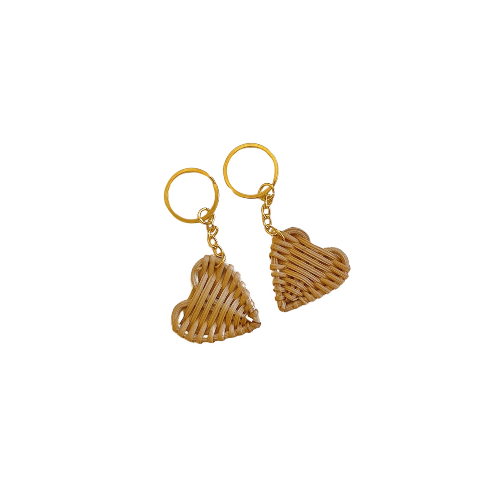 Pair of heart-shaped woven wicker keychains with golden rings.