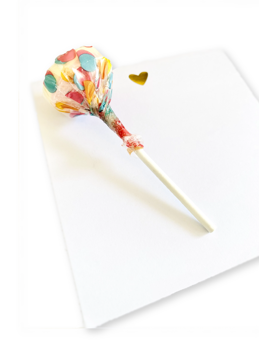 The Note Taker" pad with 50 high-quality sheets features an elegant gold foil heart design for notes and doodles. Includes a single Smarties Pops Lollipop offering a blend of two classic flavors, perfect for enjoying while jotting down thoughts.